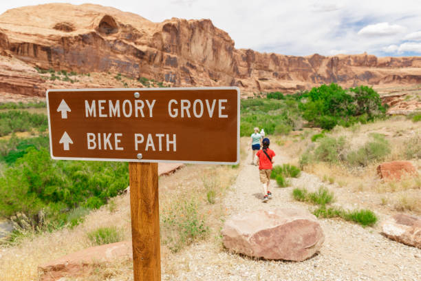 Tourist Signpost in Utah Desert with Tourists Tourist Sign in Utah Desert with Tourists Hiking on the Background Kokopelli Trail stock pictures, royalty-free photos & images